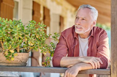 Mature gray-haired man standing with a thoughtful look