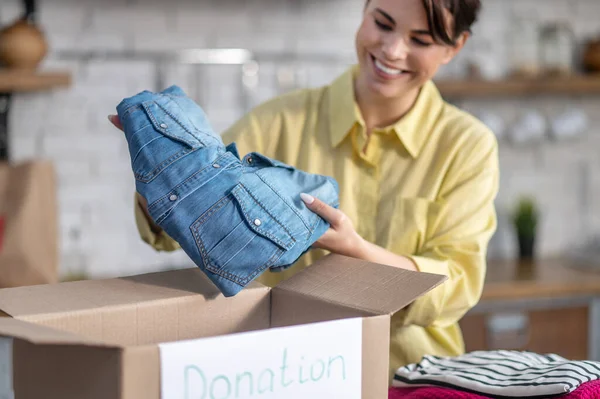 Happy lady packing her clothes for donation