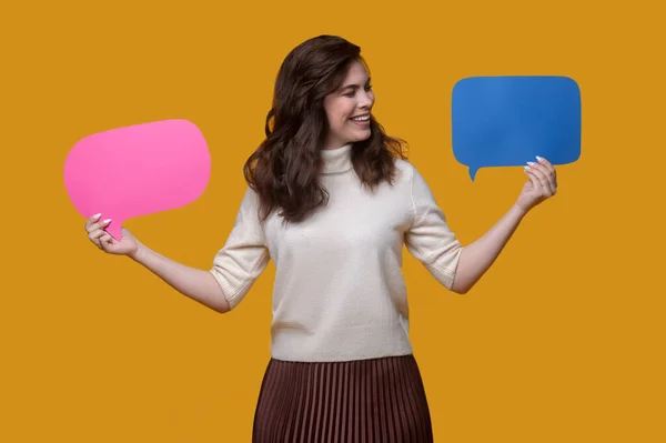 Pleased lady looking at two colorful cardboard tablets — Stock Photo, Image