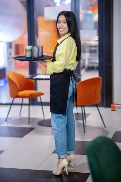 Young asian waitress with a tray in hands — Stockfoto