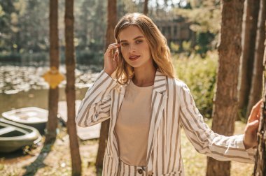 Güzel, rahat, uzun saçlı bir kadın nehir kıyısında