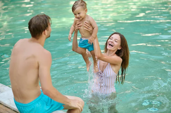 Família feliz em uma piscina — Fotografia de Stock