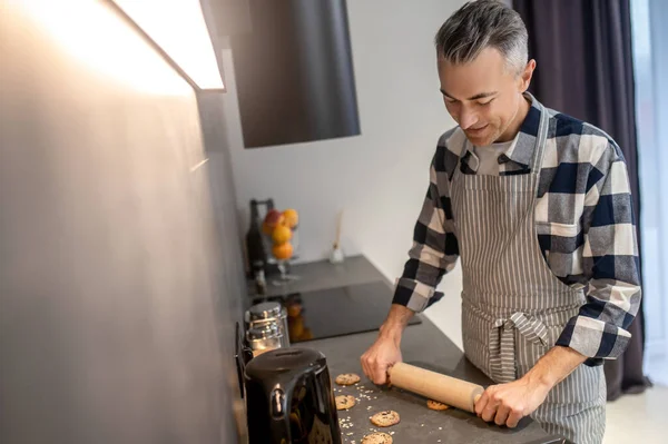 Чоловік натискає штифт на поверхню печива — стокове фото