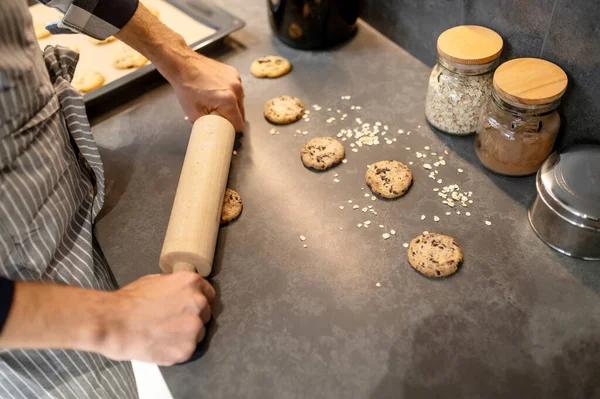 Vista dall'alto delle mani maschili stendere biscotti crudi — Foto Stock