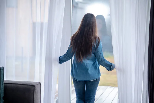 Vue arrière de la femme debout près de la porte en verre — Photo