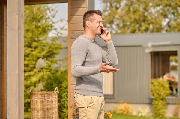 Man standing sideways to camera talking on smartphone outdoors — Stock Photo, Image