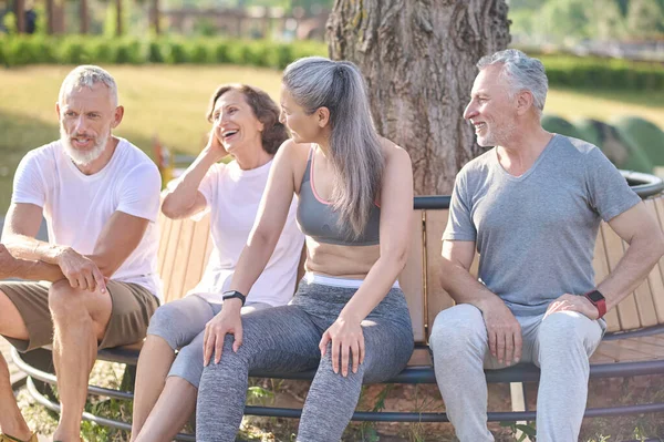 Grupp människor vilar efter träningen och känner sig glada — Stockfoto