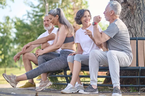 Personas de mediana edad descansando en el parque después del entrenamiento — Foto de Stock