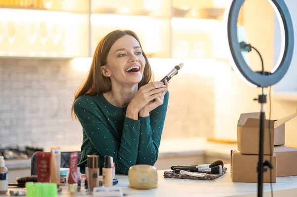 Joven cosmetólogo sonriente explicando los secretos del buen maquillaje — Foto de Stock