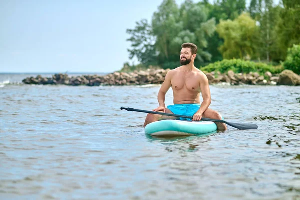 Un jeune homme brun sur un kayak — Photo