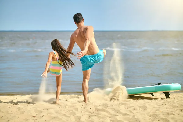 Папа и дочь играют вместе на пляже — стоковое фото