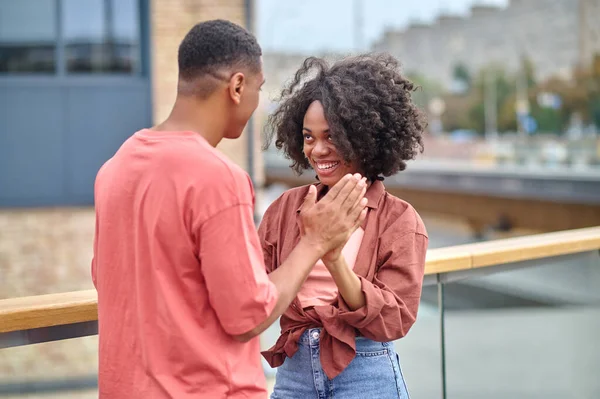 Woman and man touching palms standing on bridge — Stock Photo, Image