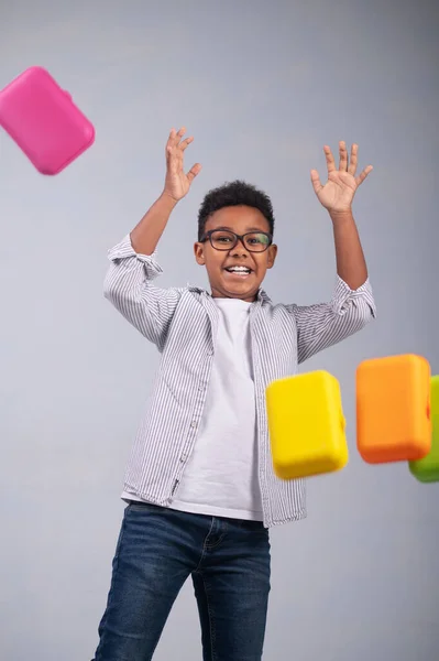 Chico con gafas posando para la cámara entre contenedores de comida voladora — Foto de Stock