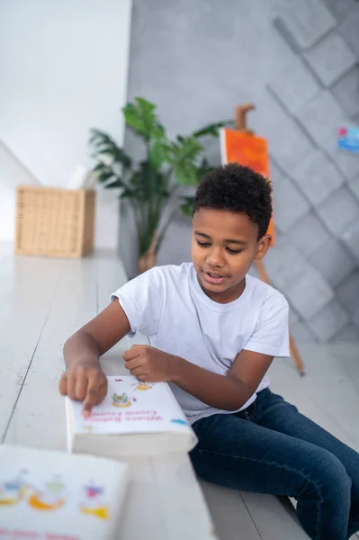 Pojke som sitter och läser bokens titel — Stockfoto