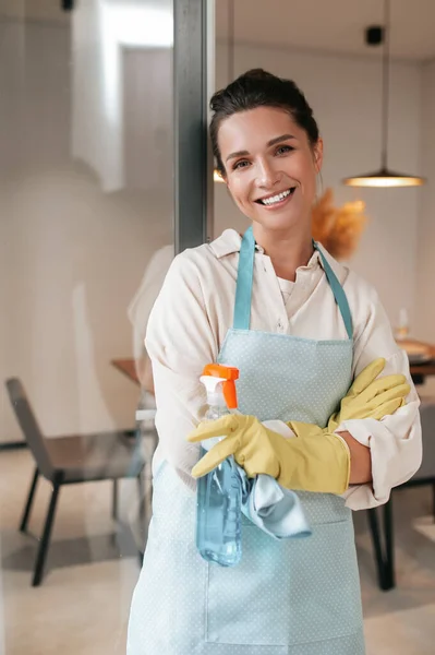 Sonriente ama de casa en delantal de pie en la cocina —  Fotos de Stock