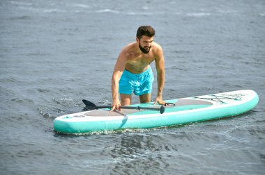 Mavi şortlu ve kanolu bir adam.