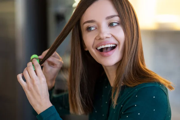 Sonriente joven mujer demostrando consejos de peinado — Foto de Stock