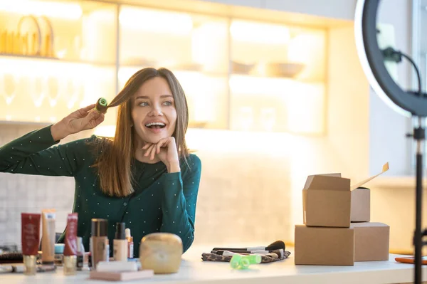 Glimlachende jonge vrouw demonstreren hairstyling tips — Stockfoto
