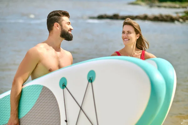 A happy couple with kayaks on a beach — Stock Photo, Image