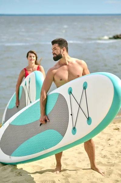 A happy couple with kayaks on a beach — Stock Photo, Image