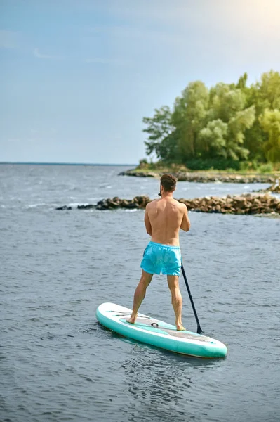 Un homme en short de bain bleu avec un kayak — Photo