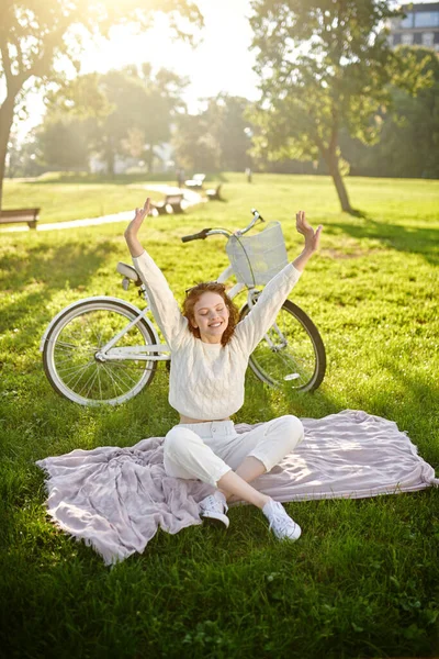 Ein junges Mädchen sitzt auf dem Gras und macht Stretching — Stockfoto