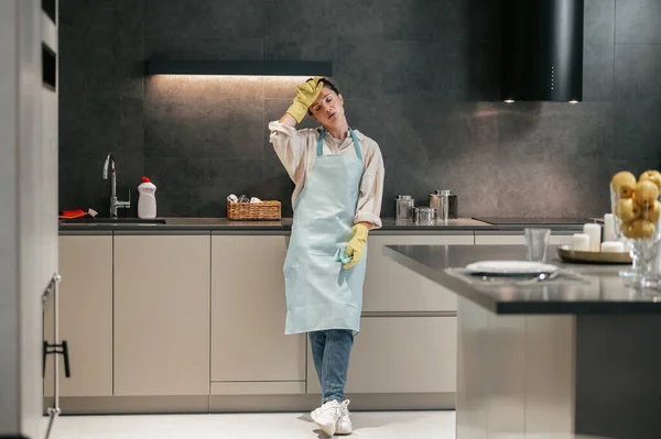 Önlüklü genç bir kadın ve mutfakta eldivenler. — Stok fotoğraf
