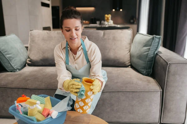 Ung kvinna gör hushållsarbete och ser upptagen ut — Stockfoto