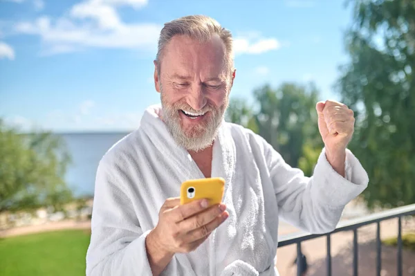 Joyous maduro homem lendo boas notícias em seu telefone — Fotografia de Stock