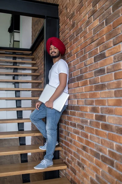 Young indian man in red turban standing on stairs — Stock Photo, Image