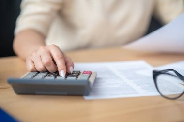 Muhasebeci, ofis masasında mali bütçe hesaplaması yapıyor.
