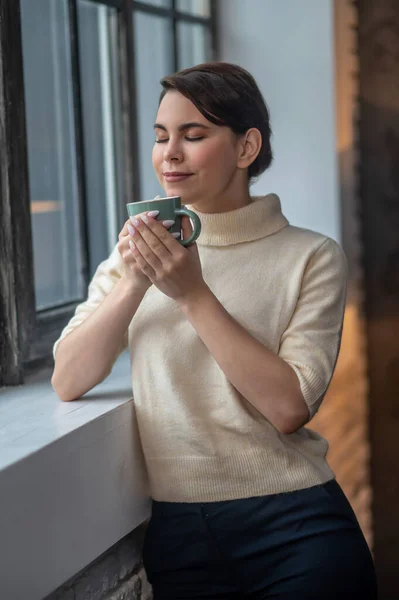 Транквіль розслаблена жінка вдихає аромат кави — стокове фото