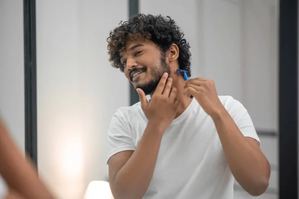 Sonriendo contento hombre enfocado mirándose a sí mismo antes de afeitarse — Foto de Stock