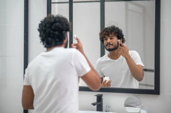 Uomo concentrato che si prepara per una procedura di rasatura — Foto Stock