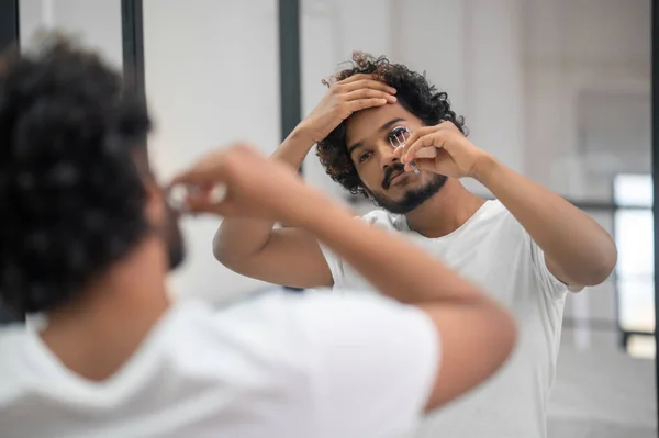 Atractivo macho indio rizando sus pestañas superiores — Foto de Stock