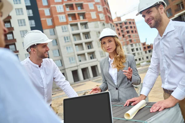 Elegant woman supervisor having a conversation with builders — Stock Photo, Image