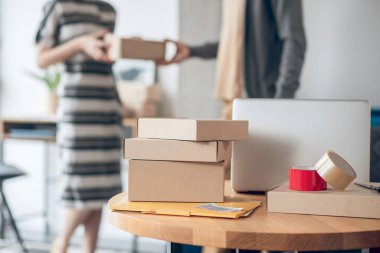 Kadın çalışan teslimatçıya bir paket teslim ediyor.