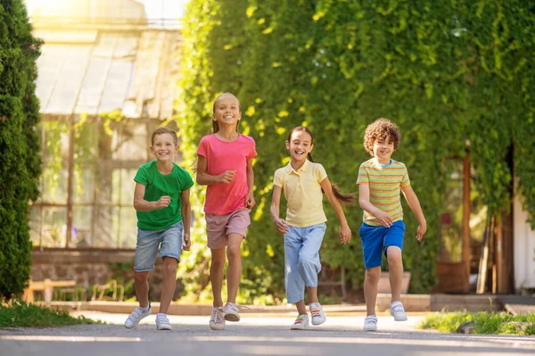 Дети, бегущие в парке в солнечный день — стоковое фото