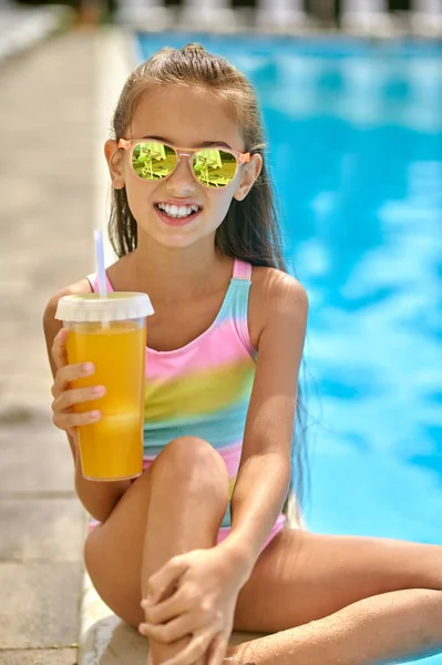 Girl with drink looking at camera near pool — Stock Photo, Image