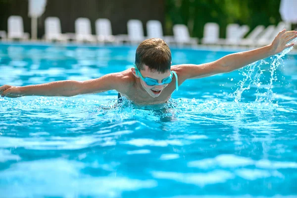 Junge fuchtelt mit im Wasser schwimmenden Armen — Stockfoto