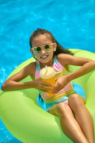 Top view of girl on inflatable ring with drink — Stock Photo, Image