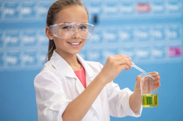 Fille avec pipette sur verre regardant caméra — Photo