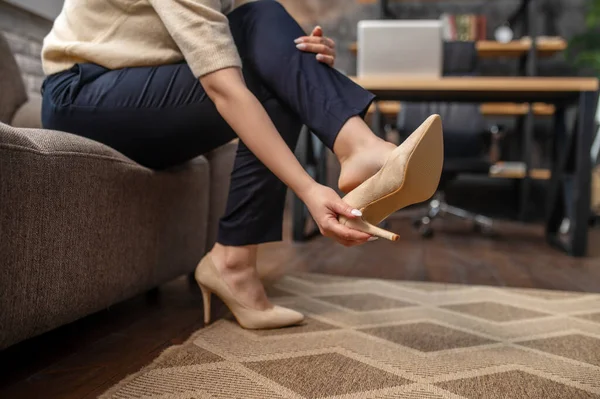 Жінка знімає стильне взуття на високих підборах на килимку — стокове фото