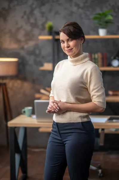 Tranquil young woman posing for the camera against her desk — Stock Photo, Image