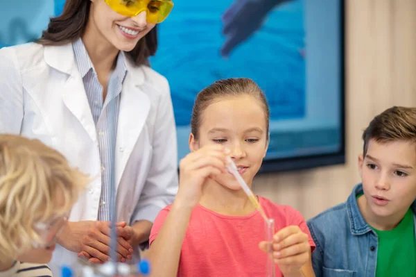 Girl adding liquid from pipette to test tube — Stock Photo, Image