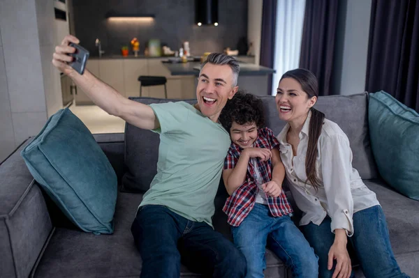 Mann macht Selfie auf Smartphone mit Frau und Sohn — Stockfoto