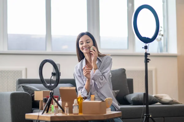 Jolie vlogger ayant un webinaire et présentant de nouveaux cosmétiques — Photo