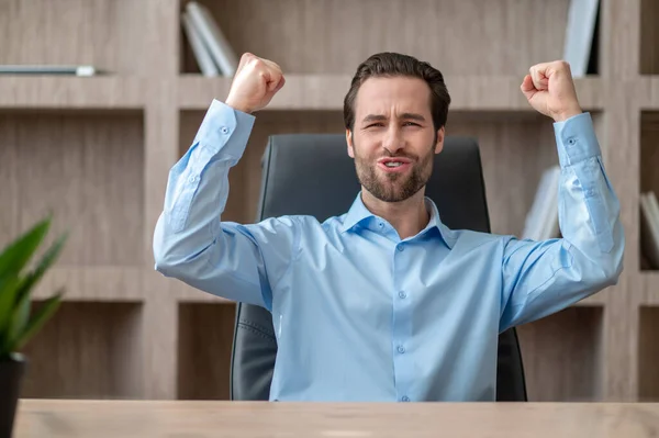 Менеджер у блакитній сорочці відчуває радісне і щасливе — стокове фото