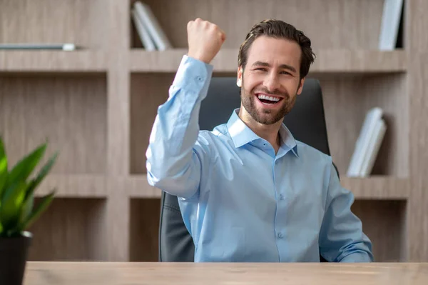 Een manager in een blauw shirt die zich vrolijk en gelukkig voelt — Stockfoto