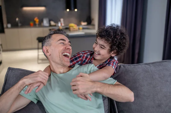 Son and father laughing looking at each other